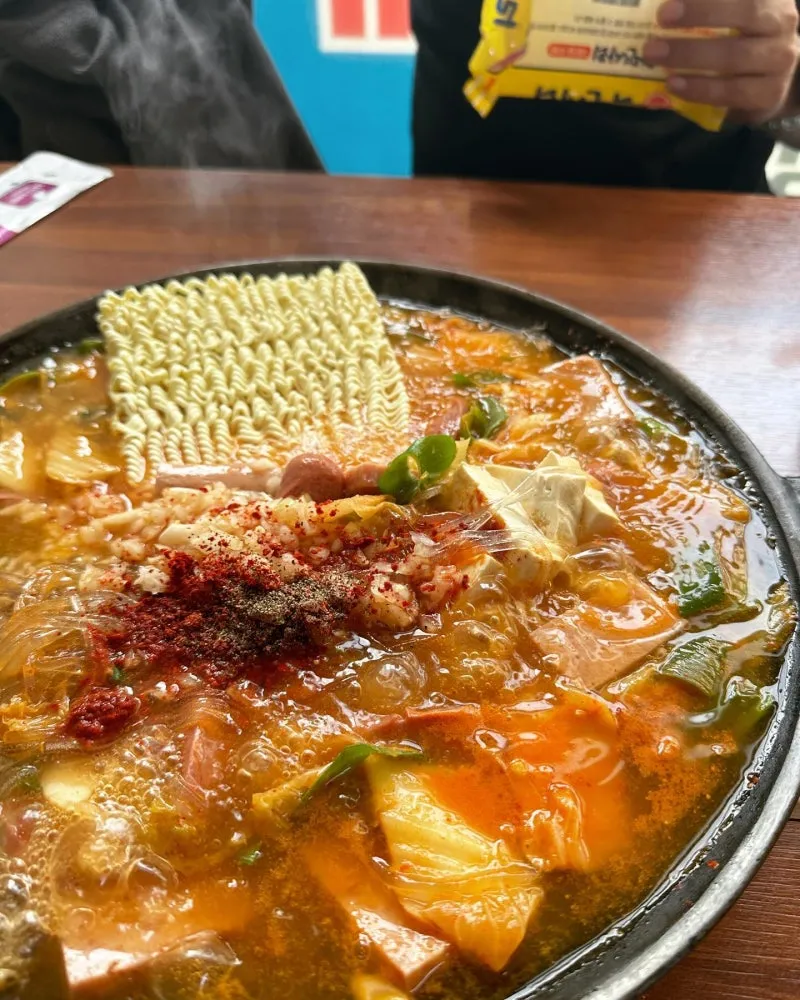 Budae Jjigae (부대찌개) – Lẩu quân đội Hàn Quốc: Khi lịch sử, nghèo khó và sáng tạo hòa quyện trong một nồi lẩu cay nồng
